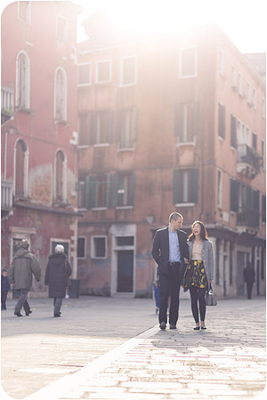 Couple standing by a canal in the misty winter light of Venice