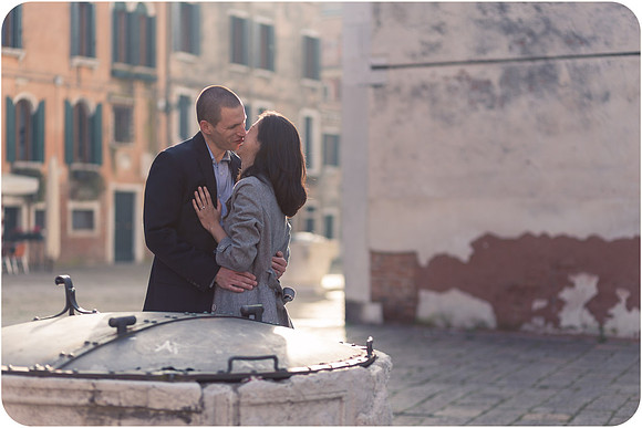 Couple standing by the edge of a canal in Venice