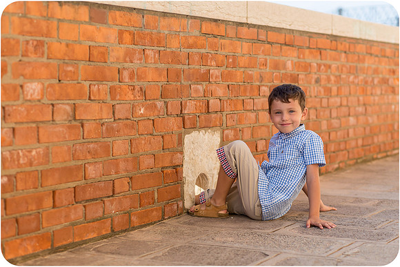 Young boy playing by brick wall in Venice