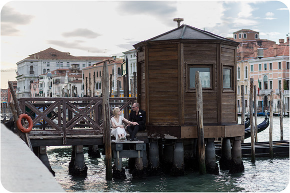 Bride and groom standing by Venetian gondolas