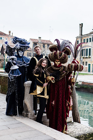 Group of masked individuals in rich Venetian carnival attire.