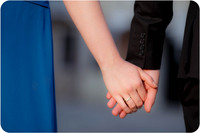 A close-up of the couple’s intertwined hands, symbolizing their connection.