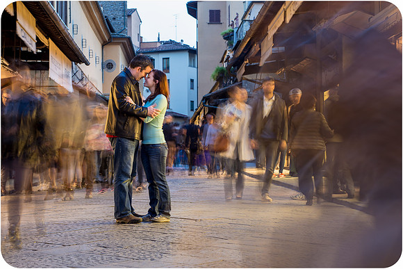Couple embracing in lively Florence streets.