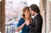 The bride-to-be smiles warmly, holding onto her fiancé's hands.