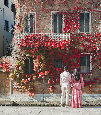 Couple walking near autumn leaves in Dorsoduro, Venice.