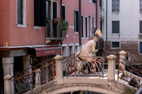 A man proposes on a charming Venetian bridge as the sun sets, capturing a once-in-a-lifetime moment.