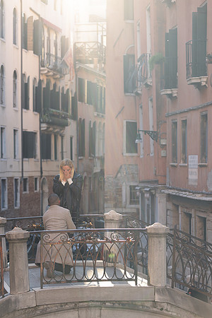 A stunning proposal under golden sunlight on a scenic bridge, making a dream come true.