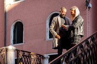 The newly engaged couple poses for a portrait on the bridge, glowing in the evening light.