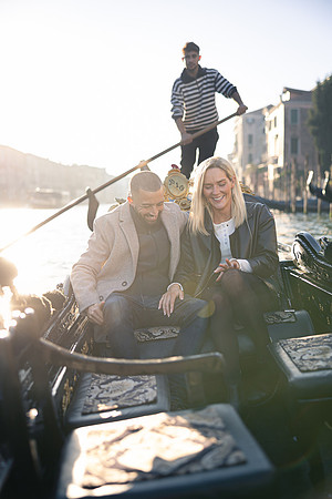 A couple enjoys a romantic gondola ride after a surprise engagement in Venice.