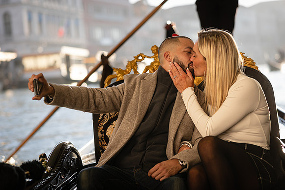 The couple shares an intimate moment in a gondola, celebrating their engagement.