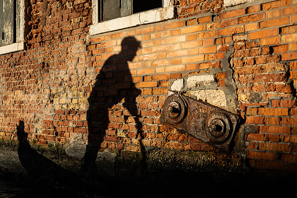 An artistic shot featuring shadows of a gondola and the newly engaged couple.