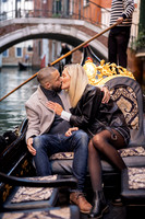 A couple lost in their engagement bliss, sharing a kiss in a traditional Venetian gondola.