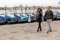 Couple walking near gondolas in Venice