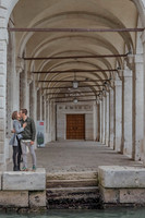 Couple kissing under Venetian archway