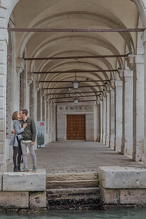 Couple kissing under Venetian archway
