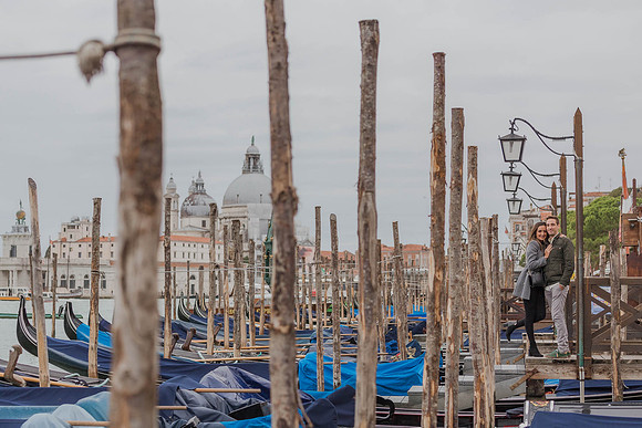 Engaged couple standing near Venice docks