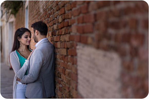 Engaged couple walking through historic Venice streets
