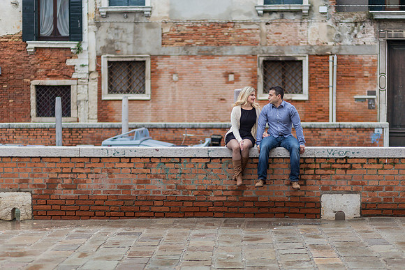 Couple posing by a peaceful canal in Venice during their engagement session