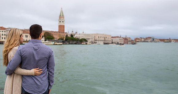 Couple on a bridge overlooking a canal in Venice