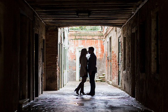Silhouette of an engaged couple under a bridge in Venice