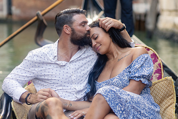 Couple embracing on gondola ride through Venice canals