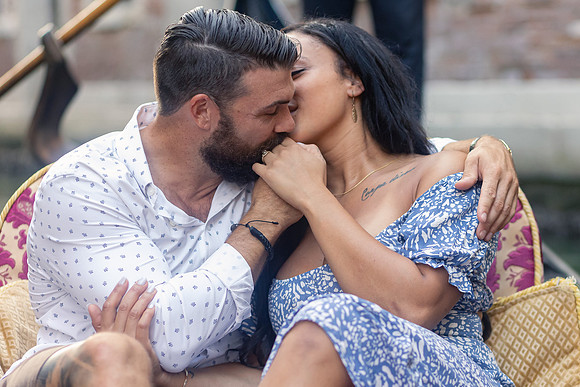 Candid moment of couple on gondola after Venice proposal