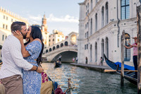 Couple kissing after proposal on gondola with Rialto Bridge