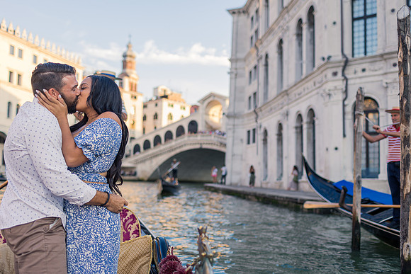 Couple kissing after proposal on gondola with Rialto Bridge