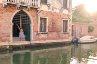 Couple walking by a Venetian canal before gondola proposal