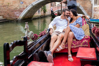 Couple riding under bridges in Venice on a gondola