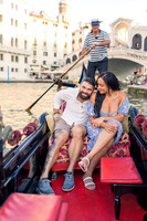 Couple on gondola with Rialto Bridge in background