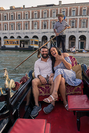 Happy couple sitting on gondola after proposal in Venice