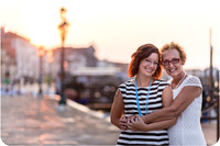 Mother and daughter sharing a happy moment by the Venice waterfront at sunrise.
