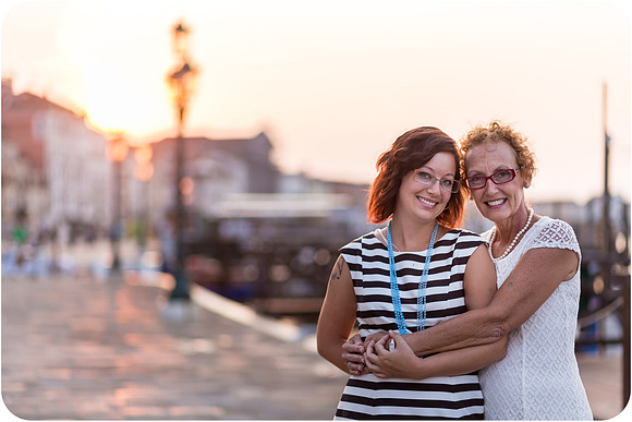 Mother and daughter sharing a happy moment by the Venice waterfront at sunrise.