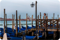 Gondolas by the water in Venice at sunrise near St. Mark's Square.