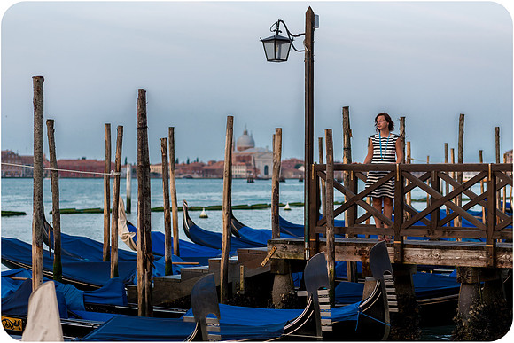 Gondolas by the water in Venice at sunrise near St. Mark's Square.