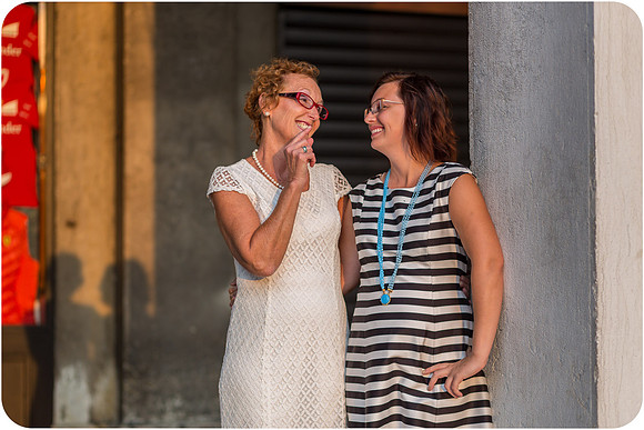 Mother and daughter sharing a playful moment by the Venetian columns during their photoshoot.
