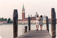 Mother and daughter standing by the water in Venice with San Giorgio Island in the background at sunrise.