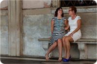 Mother and daughter sitting near the Doge's Palace in Venice, enjoying a relaxed moment.