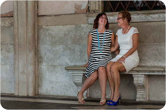 Mother and daughter sitting near the Doge's Palace in Venice, enjoying a relaxed moment.