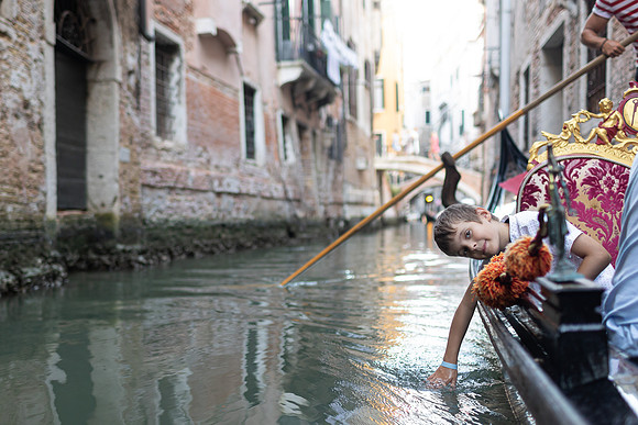 Child looking out from a gondola in Venice.