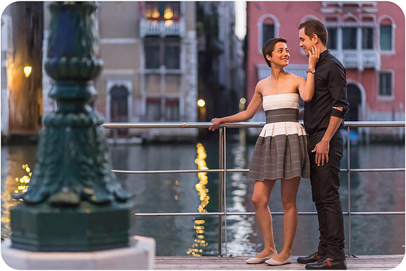 Couple standing hand in hand by the canal at sunrise in Venice