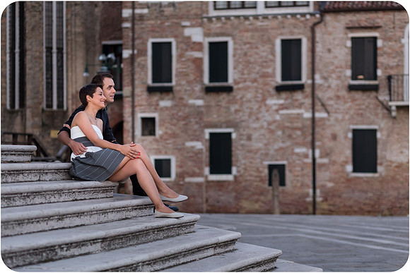 Couple sitting on stone steps in Dorsoduro at dawn