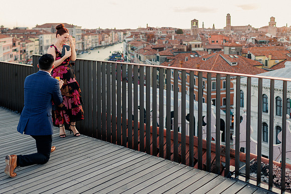 Man proposing on T Fondaco rooftop with Venice and Grand Canal view.