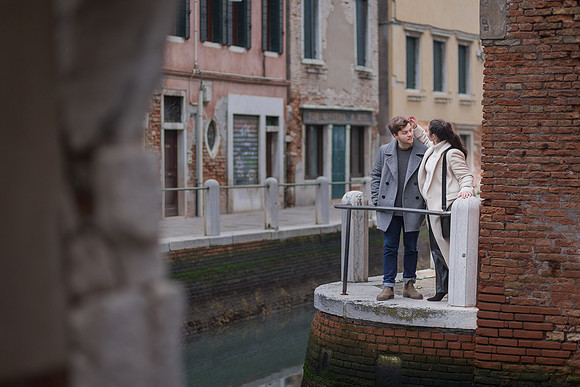 Couple admiring view from Venice canal edge