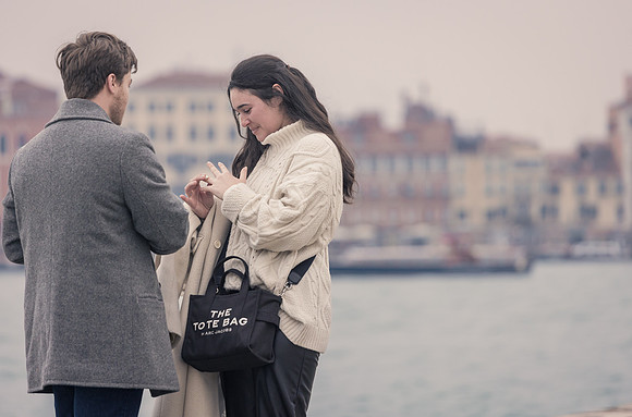Fiancée admiring engagement ring by Venice waterfront