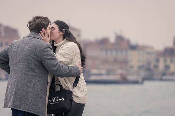 Newly engaged couple sharing kiss in Venice