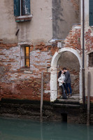 Couple embracing by historic Venetian archway