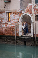 Romantic embrace by brick archway in Venice