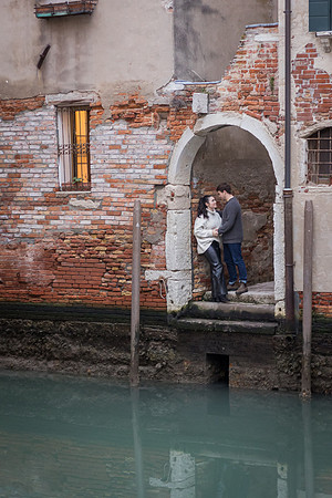 Romantic embrace by brick archway in Venice